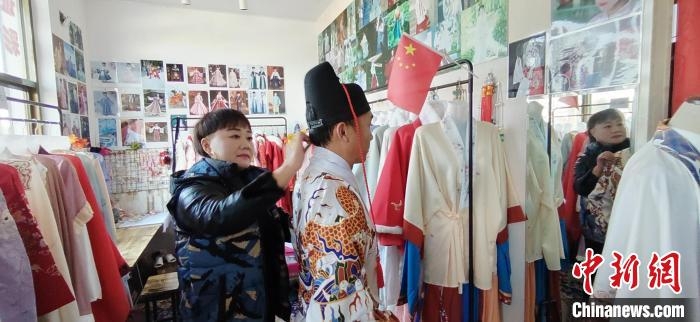 梁素梅正为慕名而来的顾客装扮戏服。　梁月仙 摄