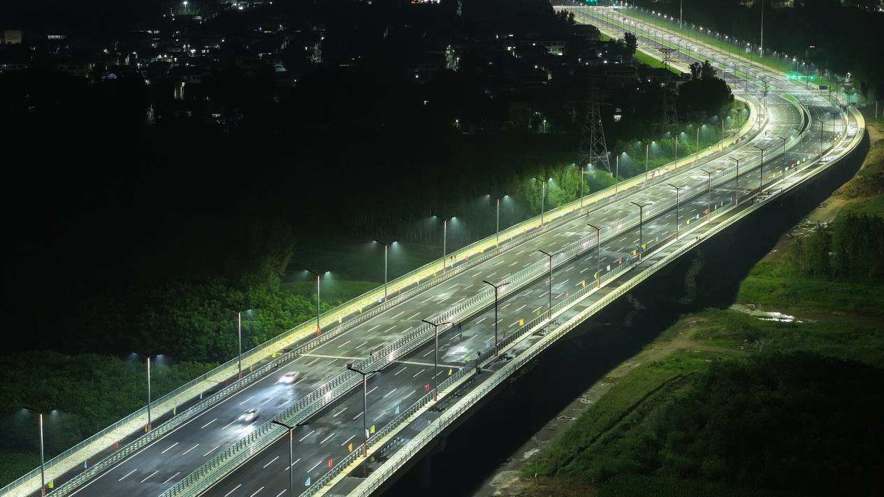 7月1日，河北省涿州市腾飞大街北延跨拒马河大桥正式通车。图为6月30日晚，车辆在大桥上试行（航拍照片）。熊华明摄