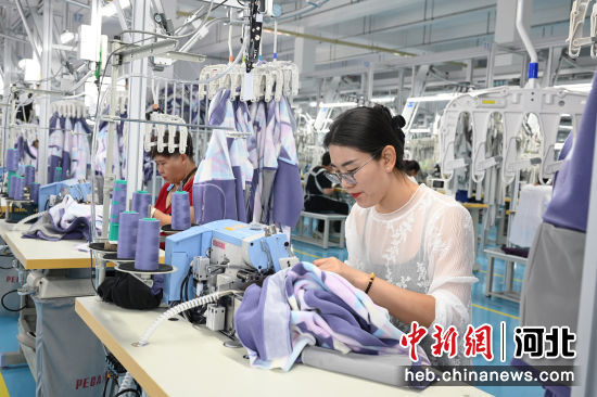 图为工人正在进行服装加工作业。 贾一凡 摄