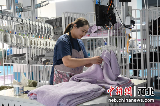 图为工人正在进行服装加工作业。 贾一凡 摄