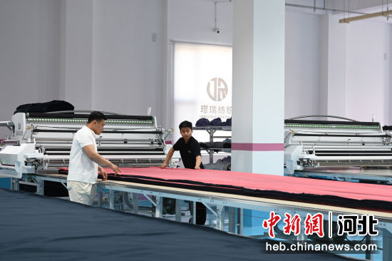 图为工人正在进行服装加工作业。 贾一凡 摄